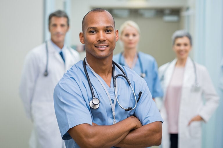 Male nurse standing in front of medical colleagues in hospital